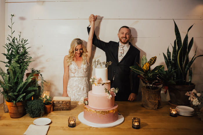 wedding couple with beautiful wedding cake and plant decor