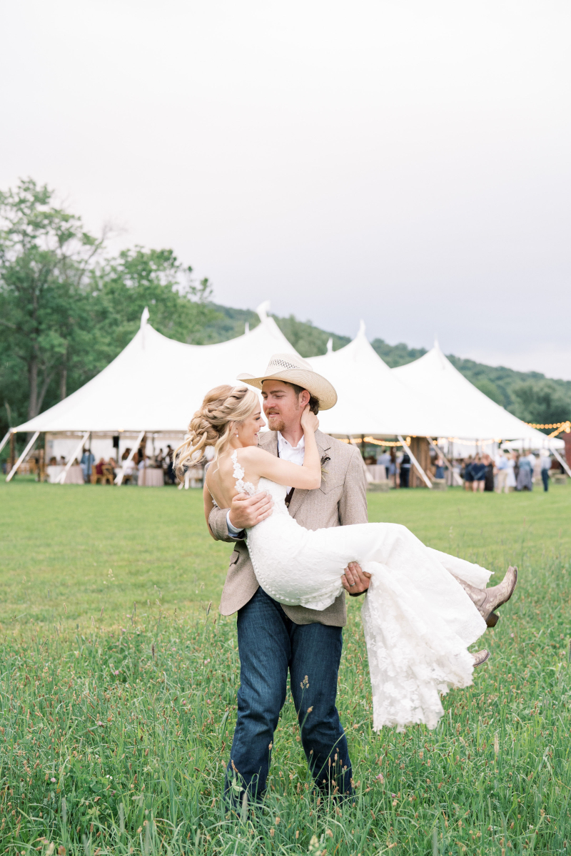 groom carries bride in wedding photos