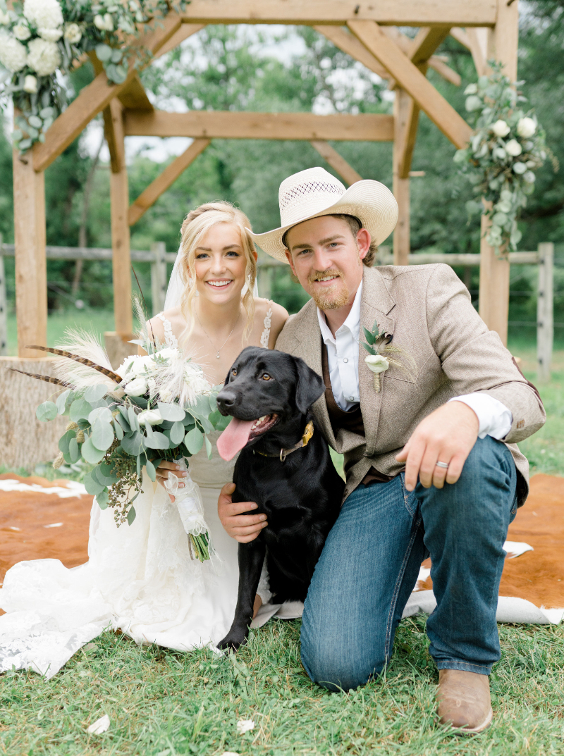bride and groom pose with their dog
