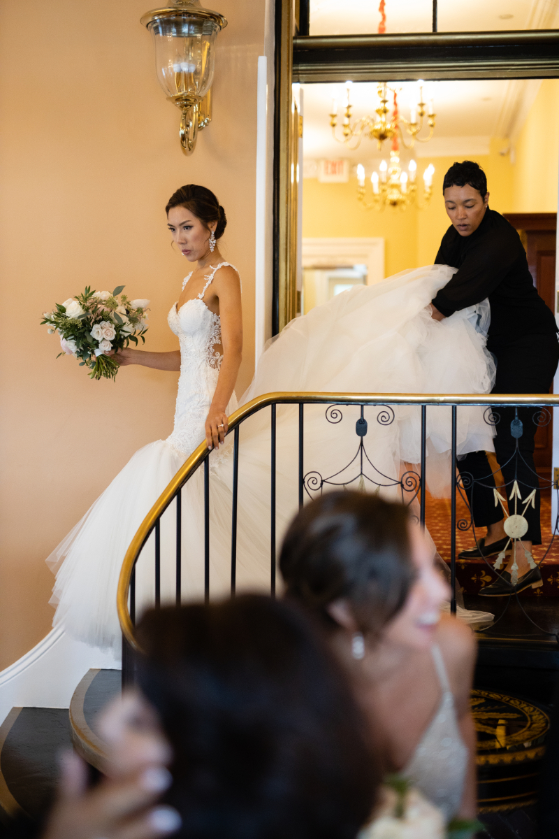 Wedding coordinator helps bride with dress