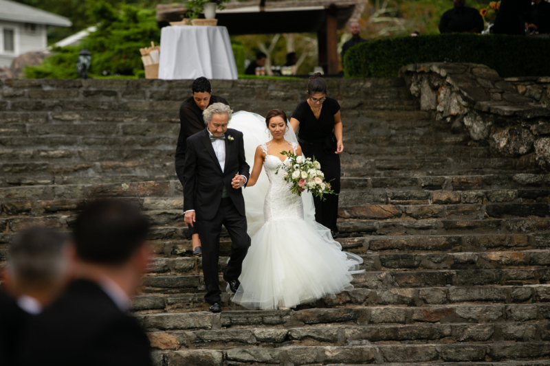 wedding coordinator helping bride down the aisle
