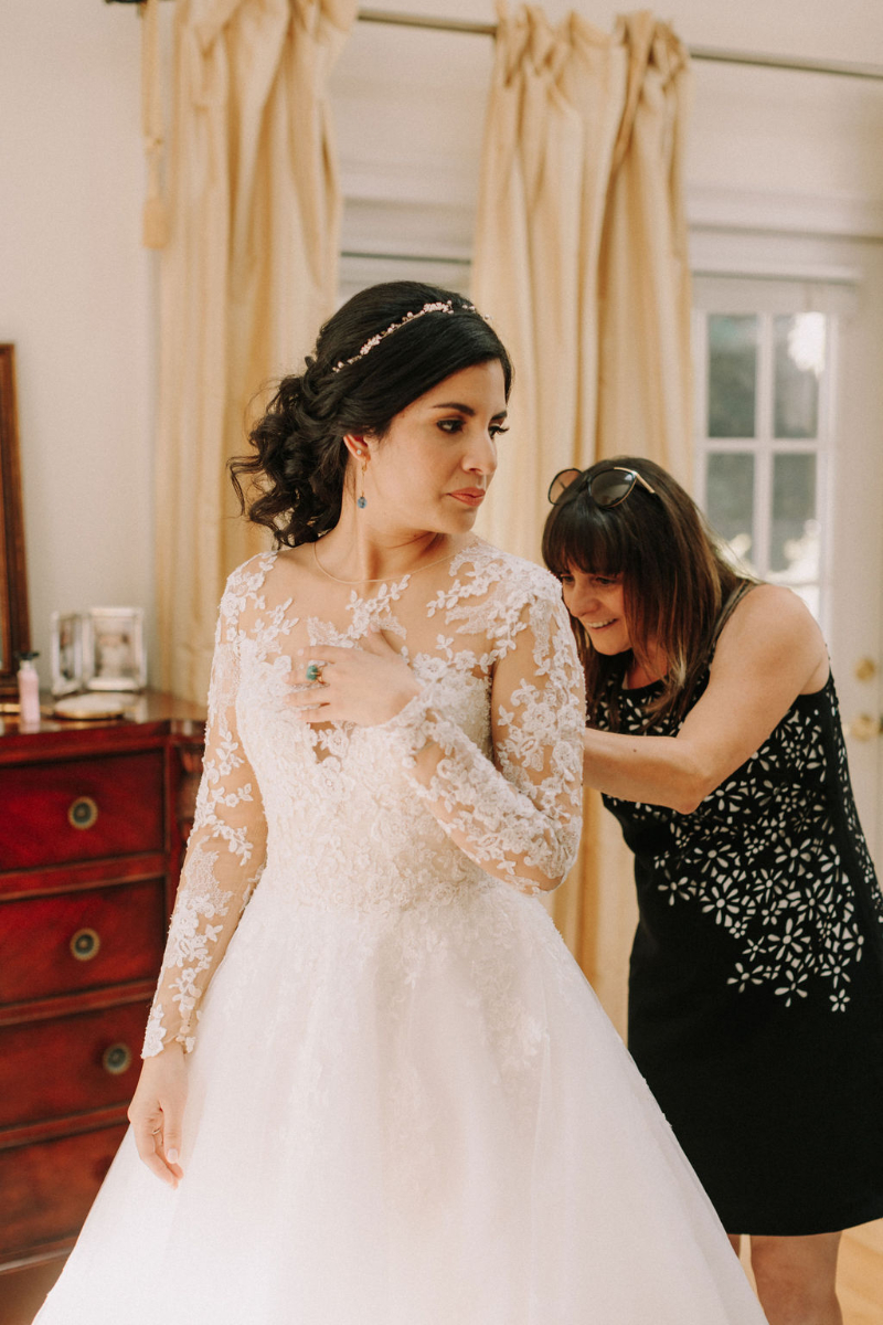 wedding planner zips up wedding dress
