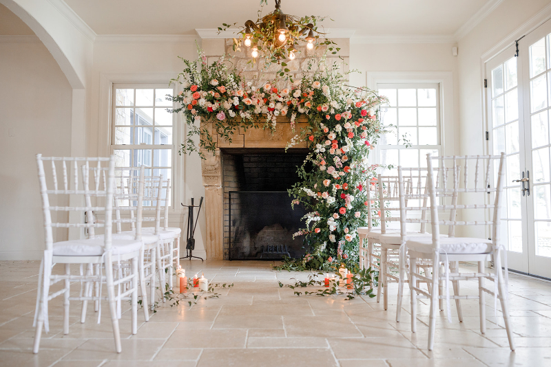 cascading florals over a fireplace for ceremony decor at Lundy Farm