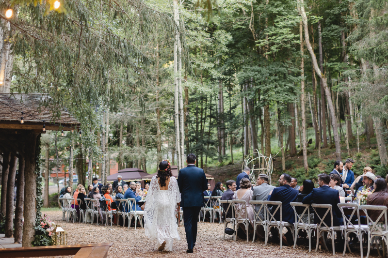bride walks down the aisle of outdoor wedding ceremony