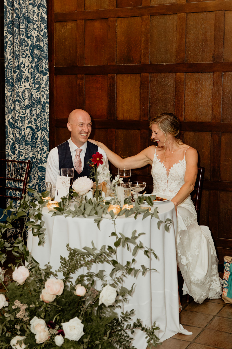 bride and groom sit at sweetheart table at wedding at Vassar College