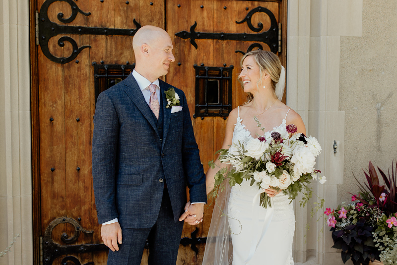 bride and groom pose outside of Vassar College