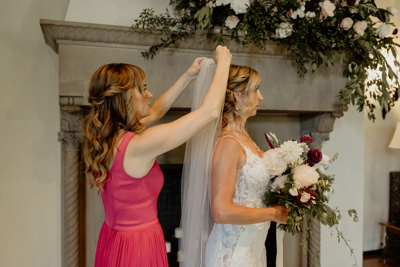 putting veil on bride