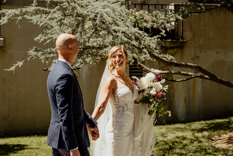 bride looks back at groom during wedding photos