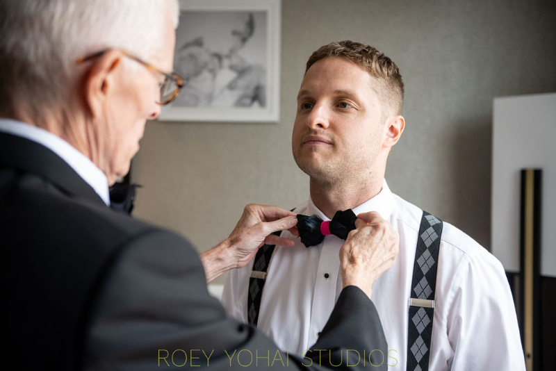 grooms dad helps put on his bow tie