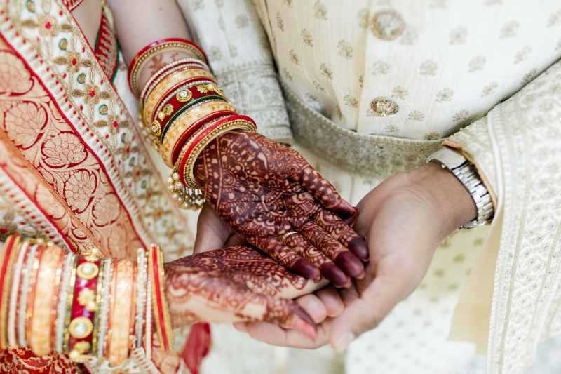 bride and groom hold hands after Indian wedding