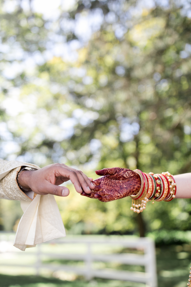 bride and groom hold hands after Indian wedding