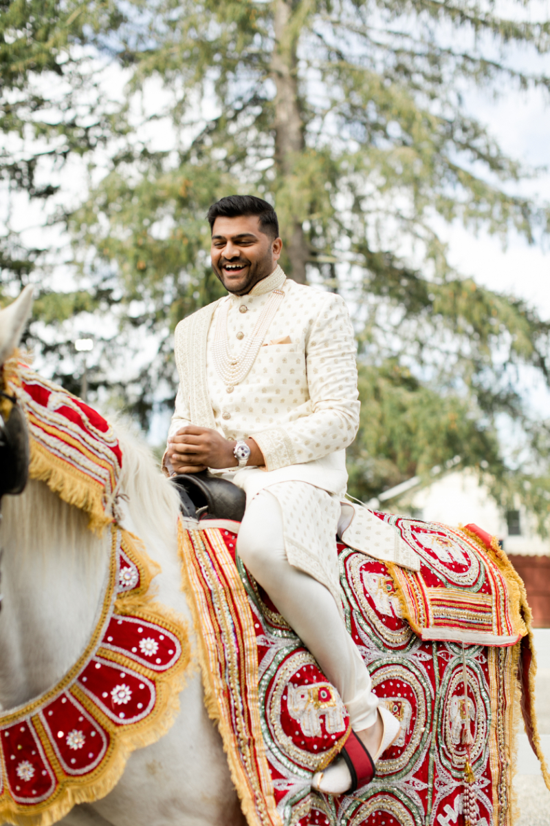 groom rides horse in Indian wedding ceremony