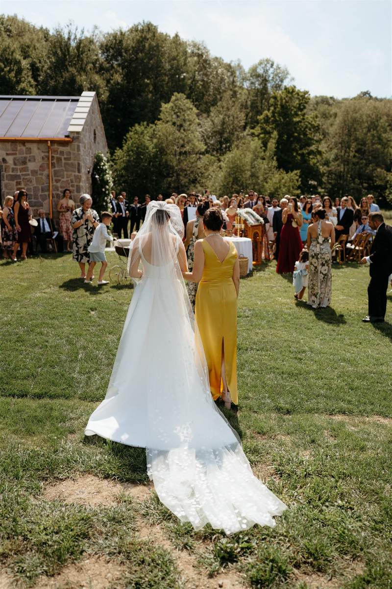 bride walks to ceremony for outdoor wedding at home in Upstate NY