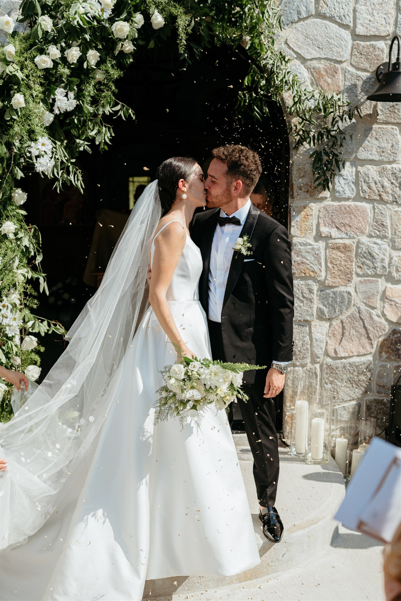 bride and groom kiss outside church