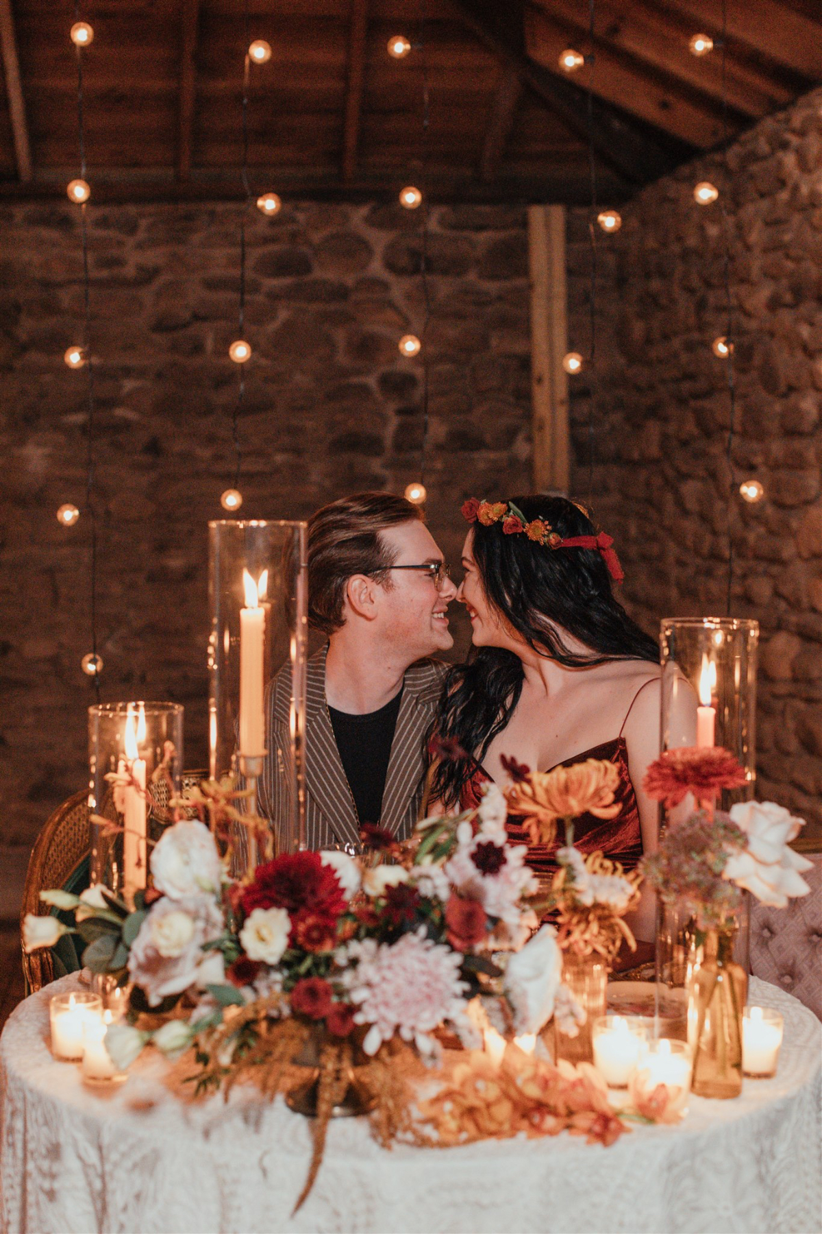 The couple seated at a candlelit table, sharing a special moment.