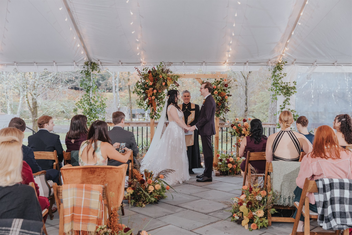 Wooden arch draped with autumn flowers, marking the spot where Emily and Greg said 'I Do.'