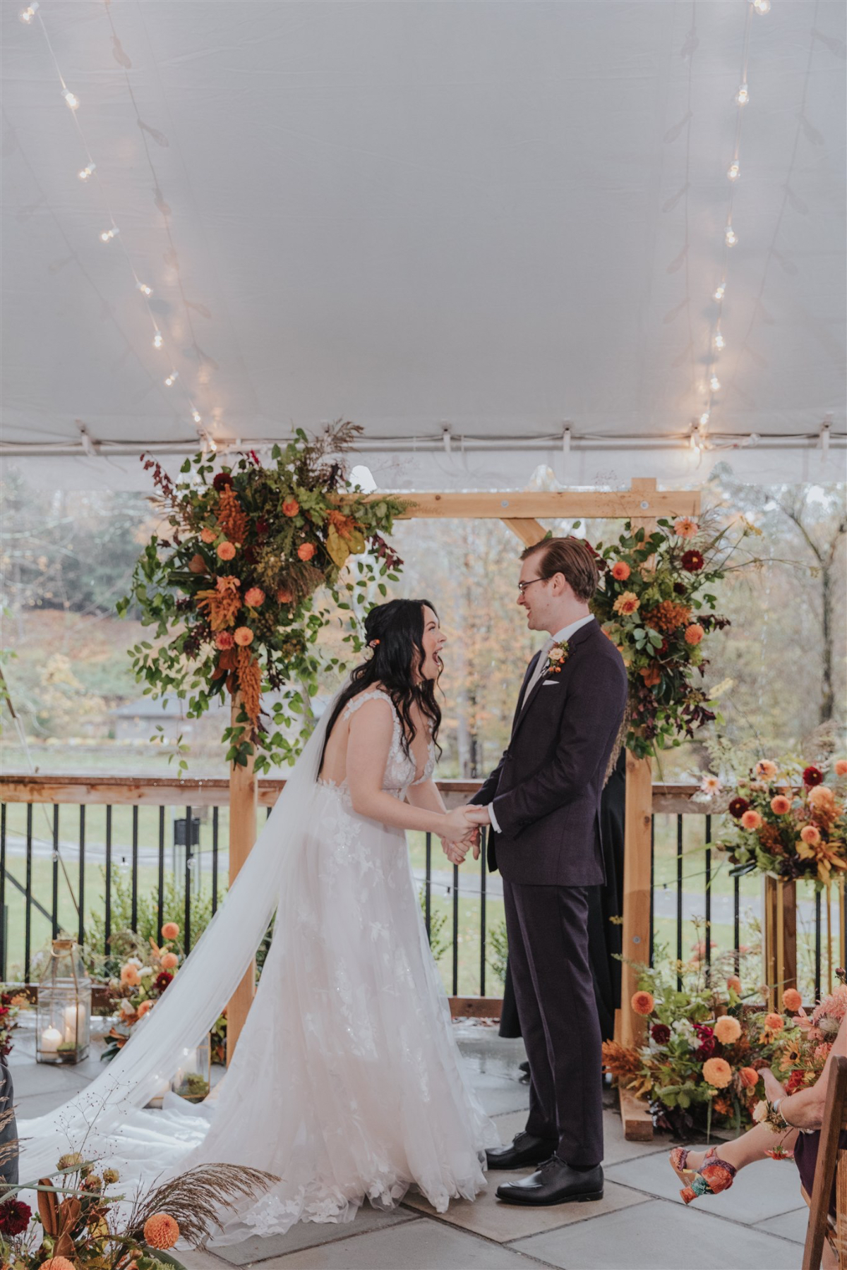 The couple's intimate ceremony space, featuring a rustic archway adorned with seasonal blooms.