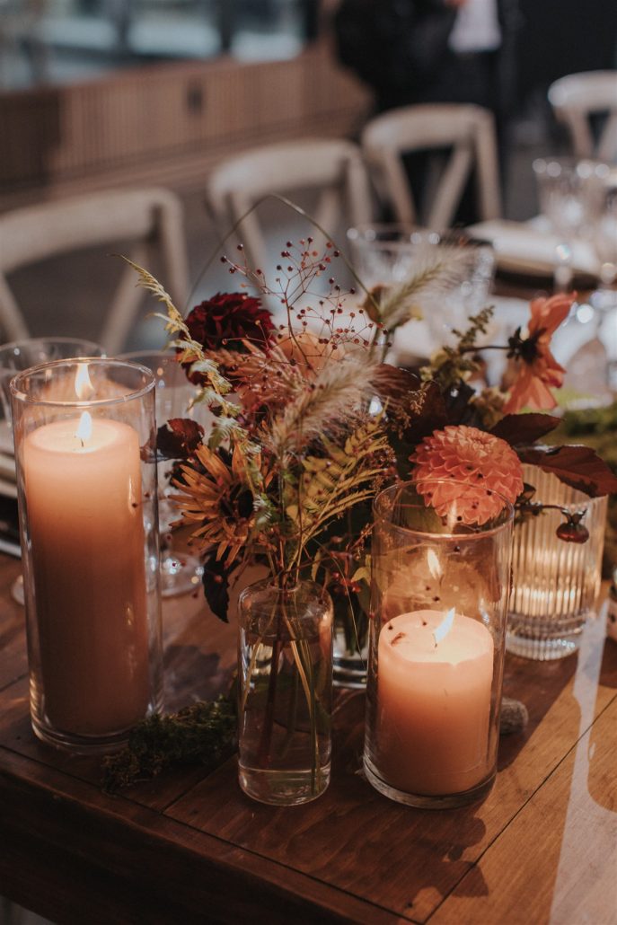 Rustic fall flowers arranged with candles.