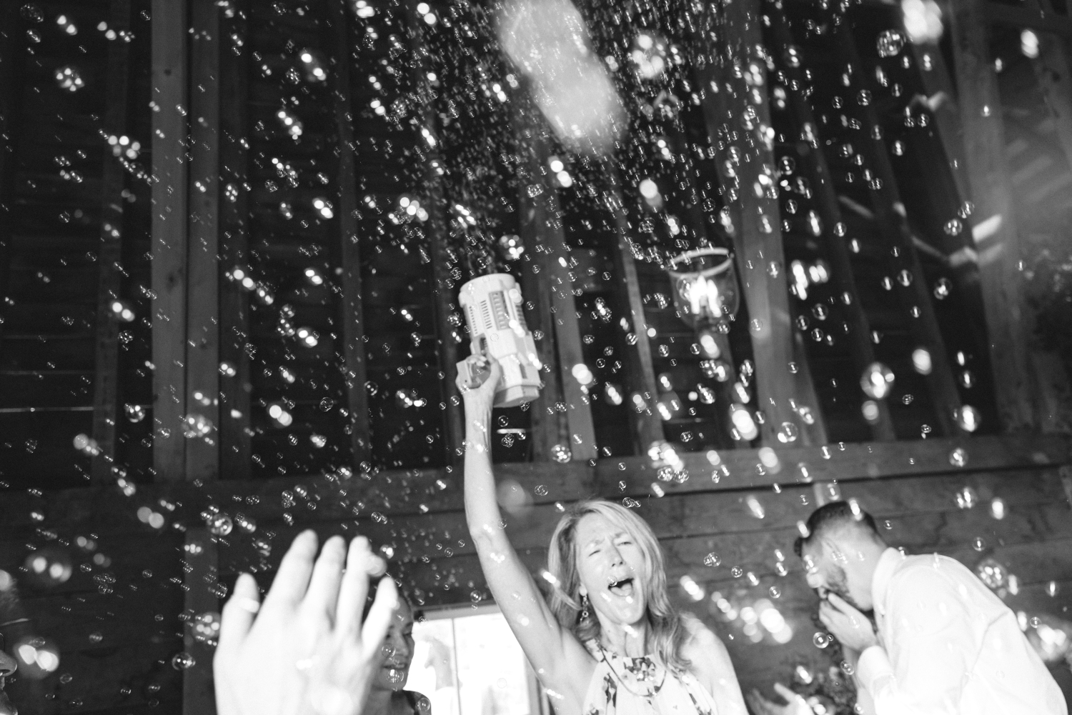black and white shot of a guest with a bubble blower and bubbles all around 