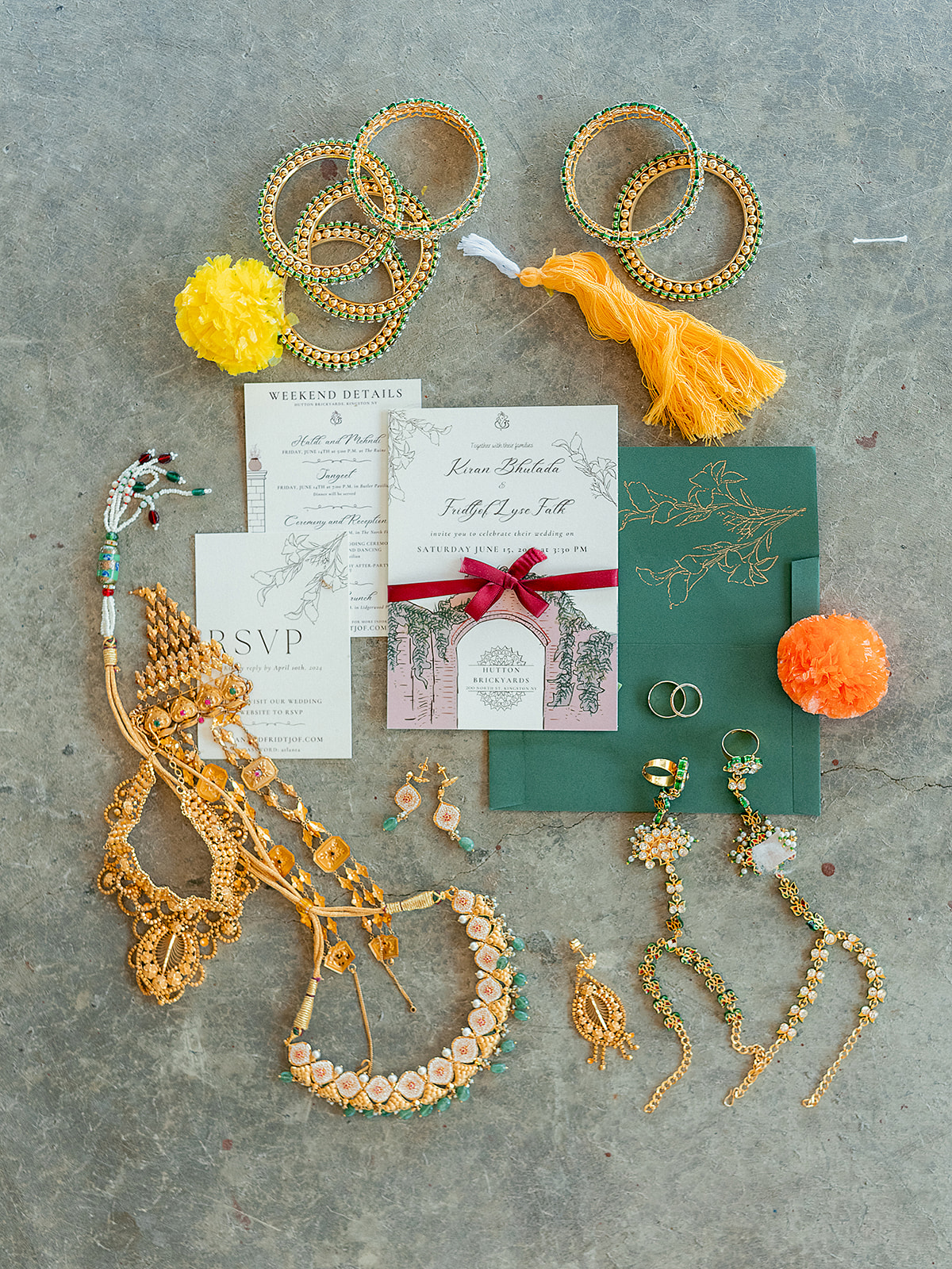 Flat lay of Indian wedding jewelry, bangles, and stationery for a vibrant multicultural celebration.