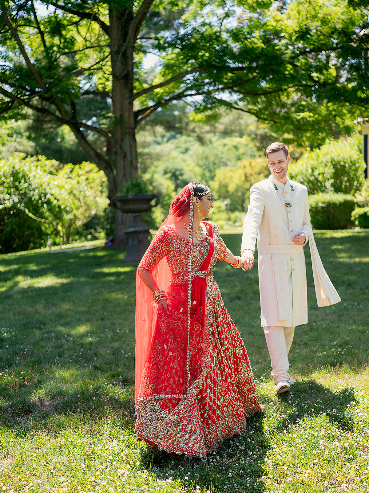 Bride and groom walking hand in hand during their Indian wedding weekend in the Hudson Valley.