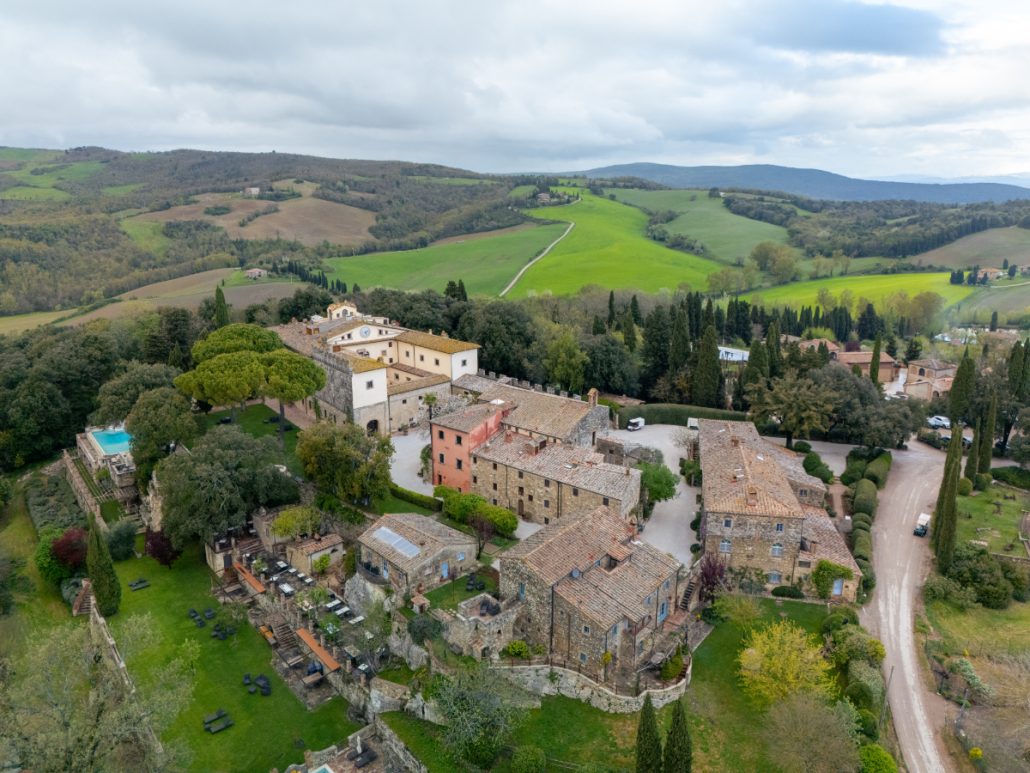 Hilltop Tuscan borgo with rustic stone buildings and panoramic countryside views, a romantic wedding venue setting.