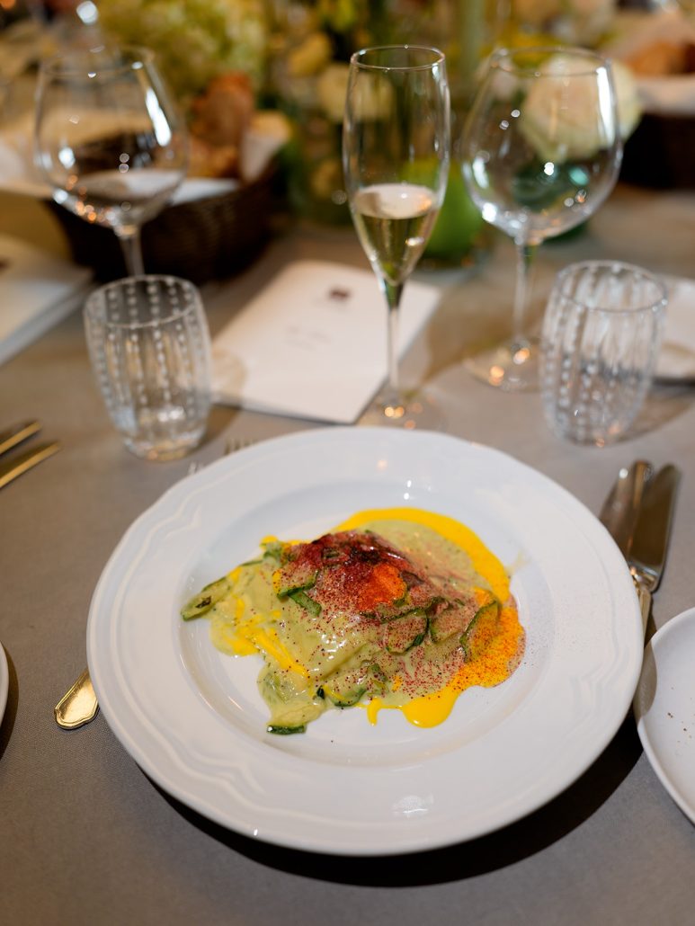 Gourmet plated dish with champagne at COMO Castello Del Nero, an Italian wedding venue in Tuscany known for Michelin-starred dining.