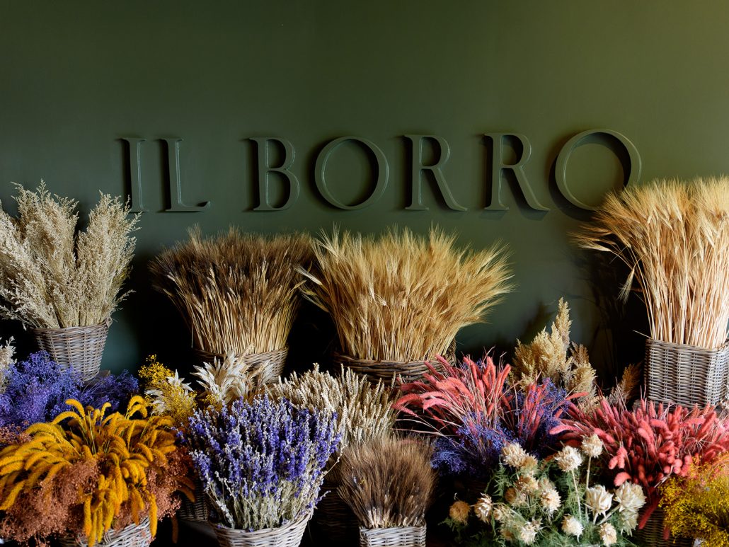 Decorative baskets of dried flowers under the Il Borro sign, evoking rustic elegance for a Tuscan wedding celebration.