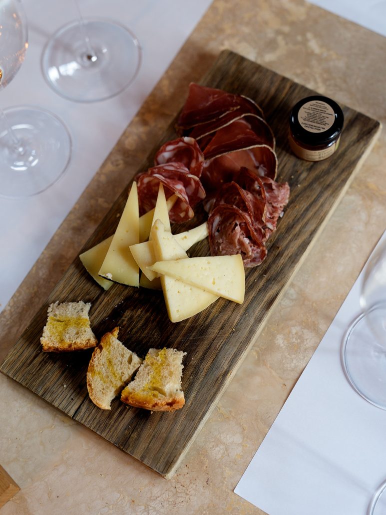 Wooden board with Tuscan meats, cheeses, and bread at Il Borro, ideal for wedding receptions in Tuscany.