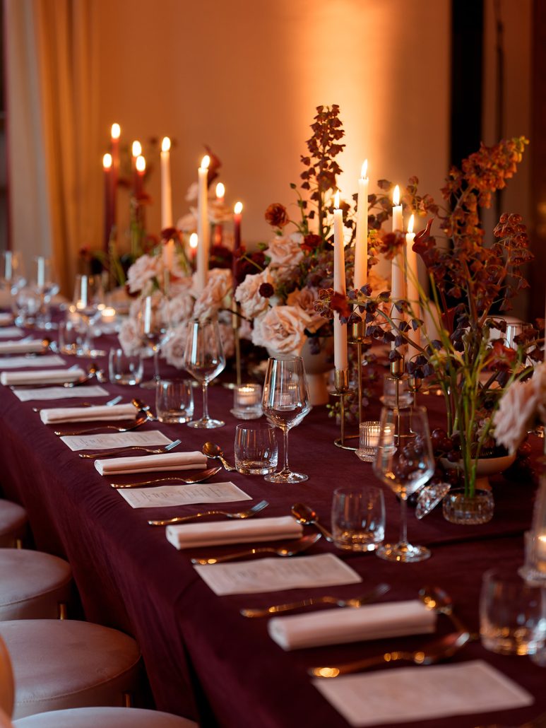 Long banquet table at Viesca Toscano decorated with tall candles, flowers, and elegant glassware, ideal for Tuscan destination wedding dinners.