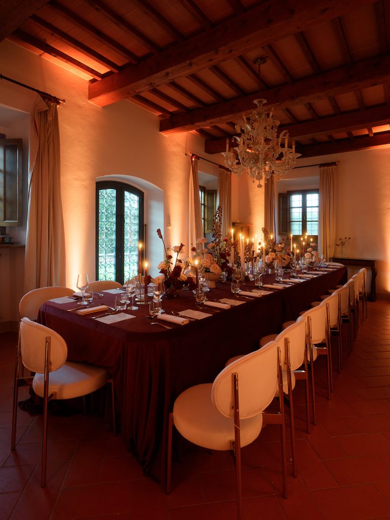 Romantic wedding reception at Viesca Toscano in Tuscany, featuring candlelit tables, floral décor, and a warm ambiance inside a rustic villa.