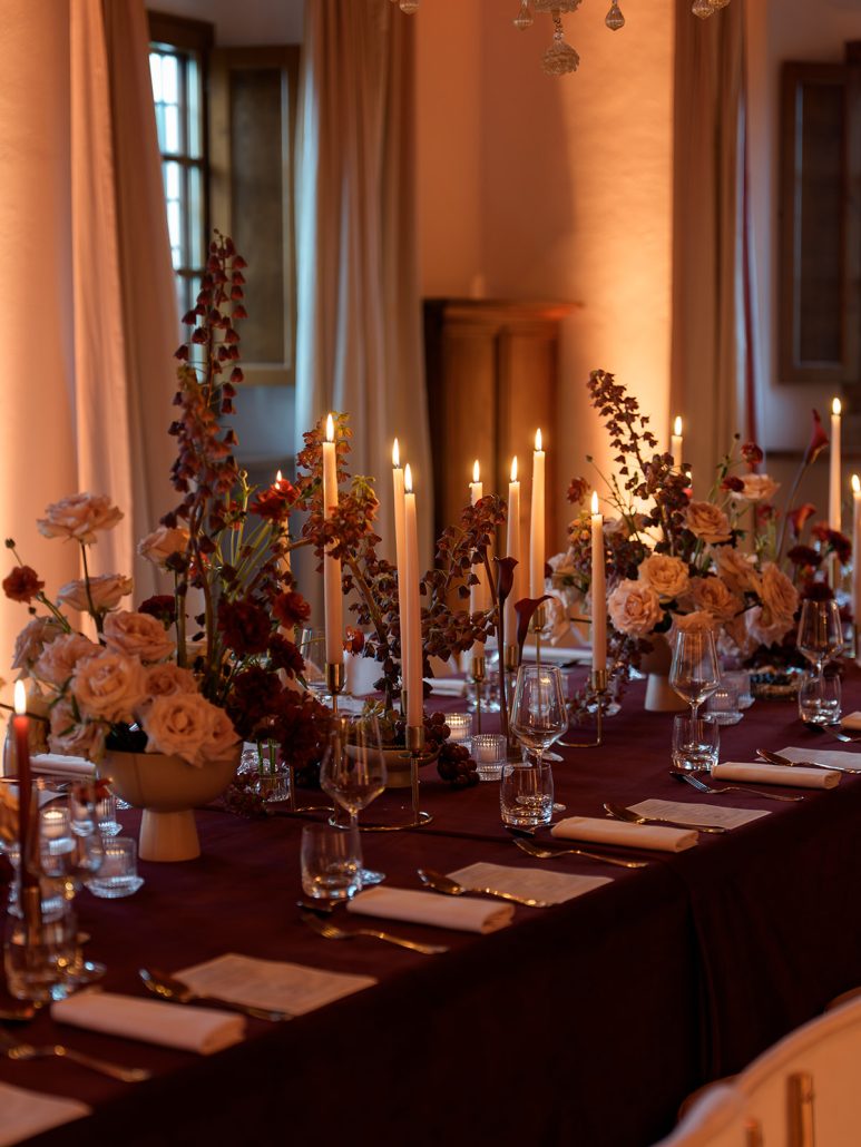 Elegant Tuscan wedding table at Viesca Toscano styled with roses, taper candles, and wine glasses for a refined destination wedding celebration.