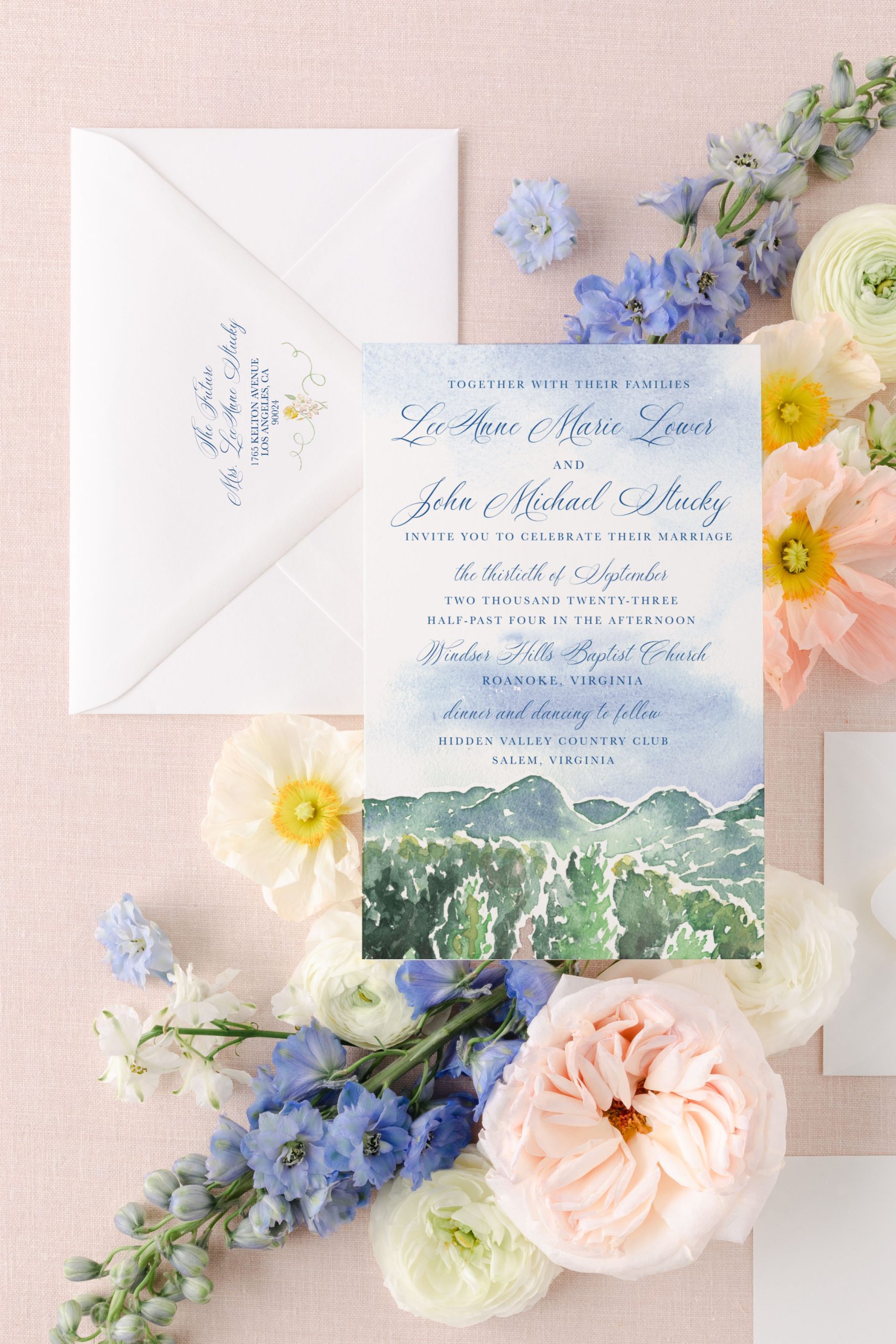 Scenic wedding invitation suite with green mountain illustration and pastel florals, ideal for mailing to out-of-town guests.