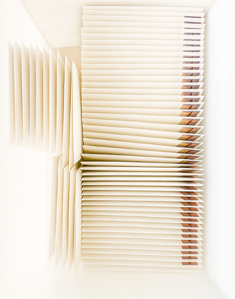 A sculptural arrangement of cream-colored envelopes, offering a modern take on mailing wedding invitations.