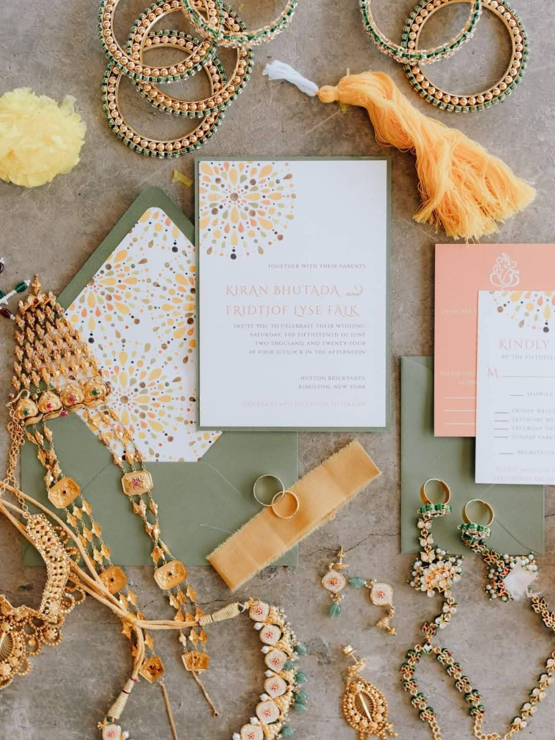 A detailed look at a colorful flat lay of wedding jewelry and printed invitations, perfect for mailing wedding invitations with personality.
