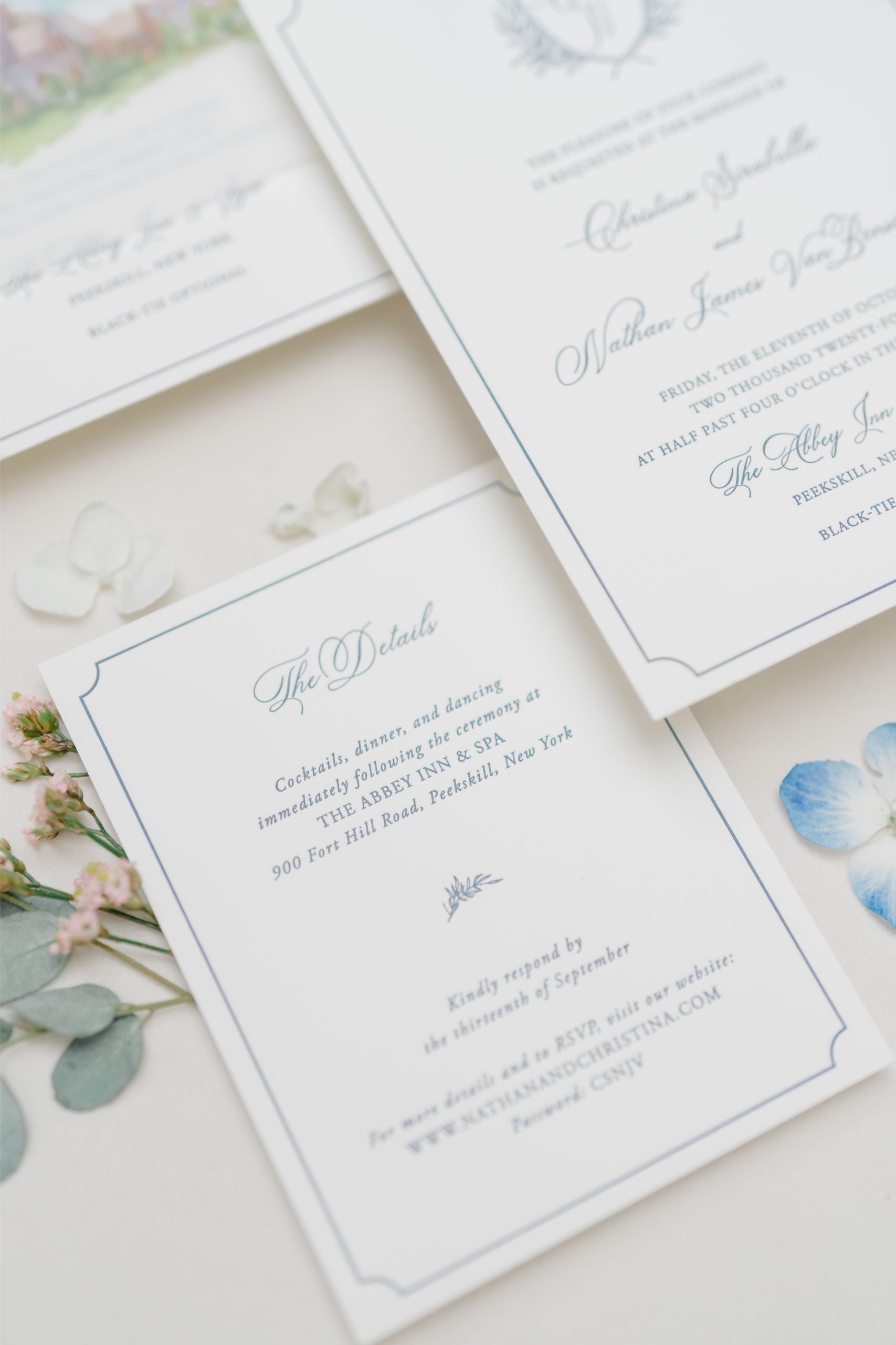 Classic white and navy wedding invitations with elegant typography and floral accents, prepared for mailing to guests.
