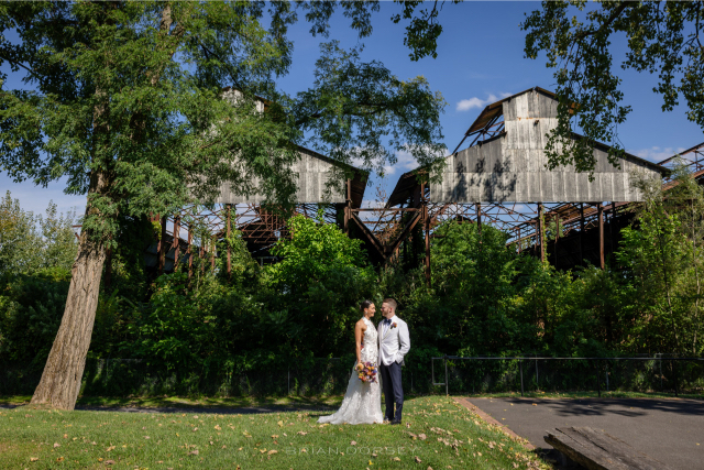 Bride and groom sharing a quiet moment in front of the rustic industrial structures at Hutton Brickyards Hudson River wedding.