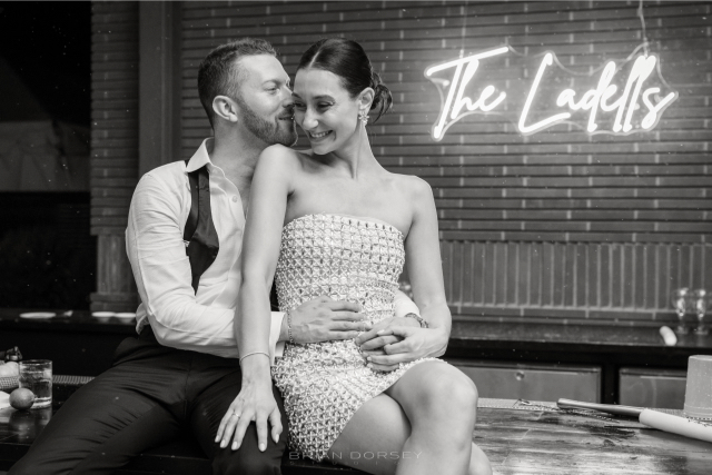 Bride and groom embracing under neon sign during their late-night celebration at Hutton Brickyards Hudson River wedding.