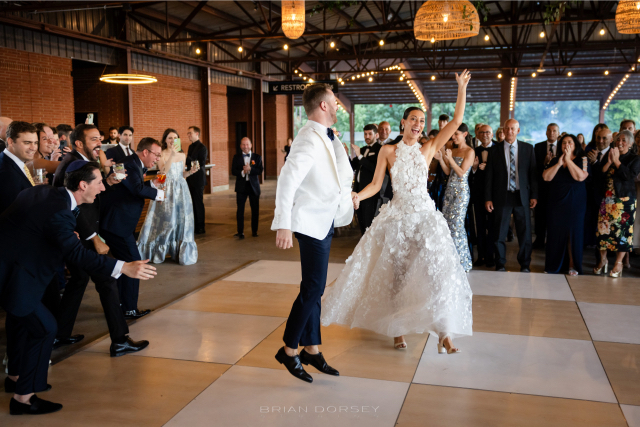 Bride and groom dancing joyfully during their summer Hudson River wedding celebration.