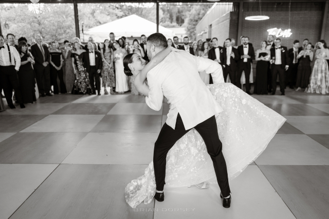 Groom dipping the bride at the end of their first dance as guests applaud at Hutton Brickyards.