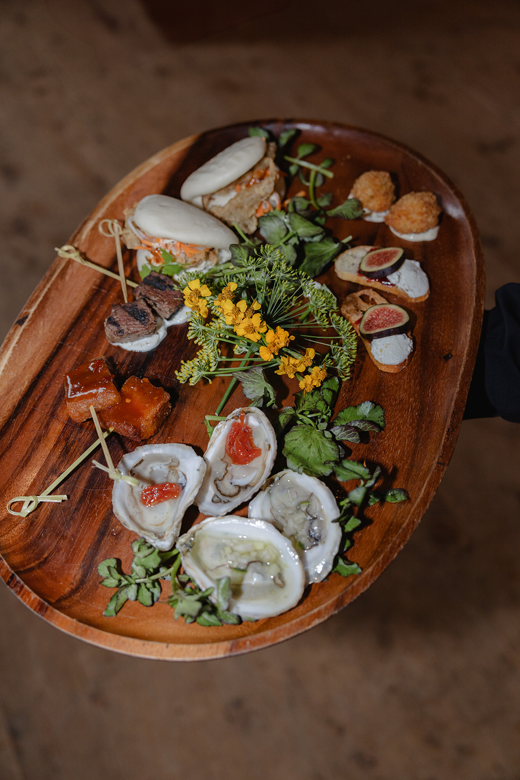 Guests enjoying roaming oysters and champagne during cocktail hour, showcasing elegant wedding food presentation.