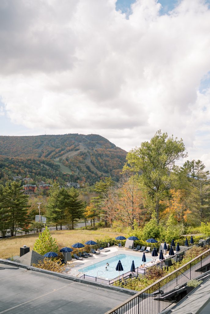 A scenic view of the mountains with the lodge’s pool area below on a bright fall day.