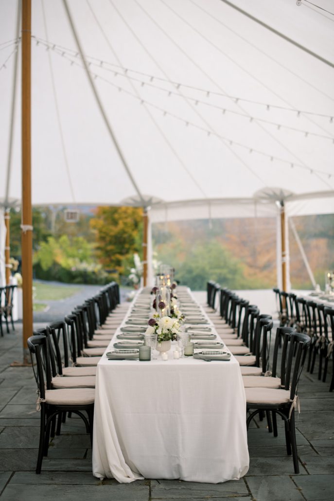 Long banquet tables set with modern décor under a sailcloth tent for a Scribner’s Catskill Lodge wedding reception.