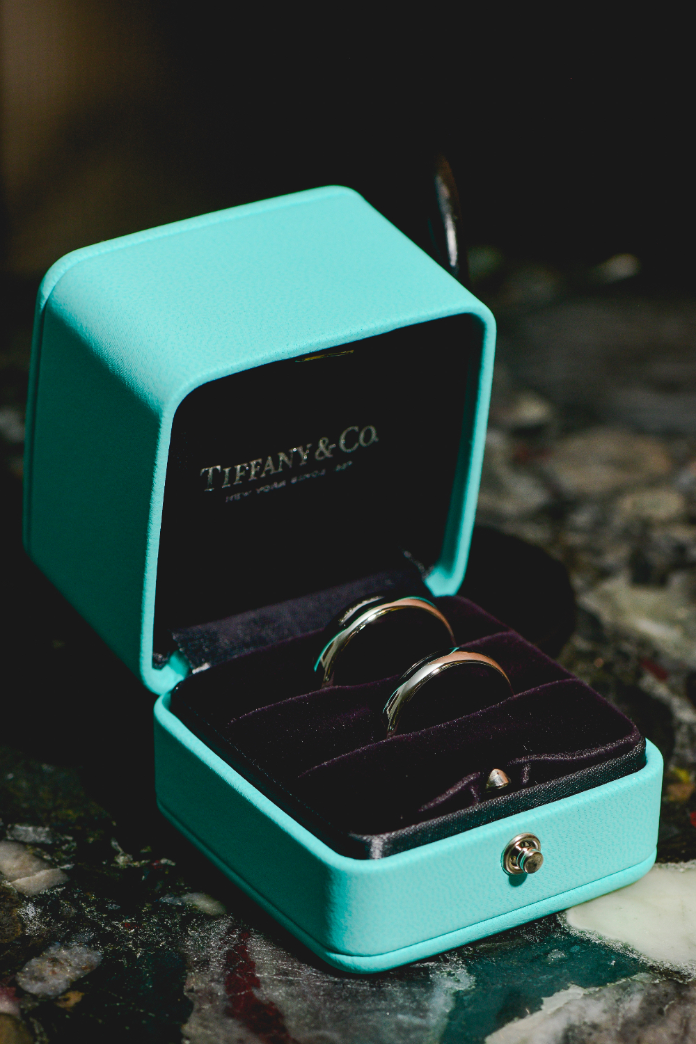 A Tiffany & Co. ring box holds two silver wedding bands, captured as part of a Buttermilk Falls Inn wedding detail.