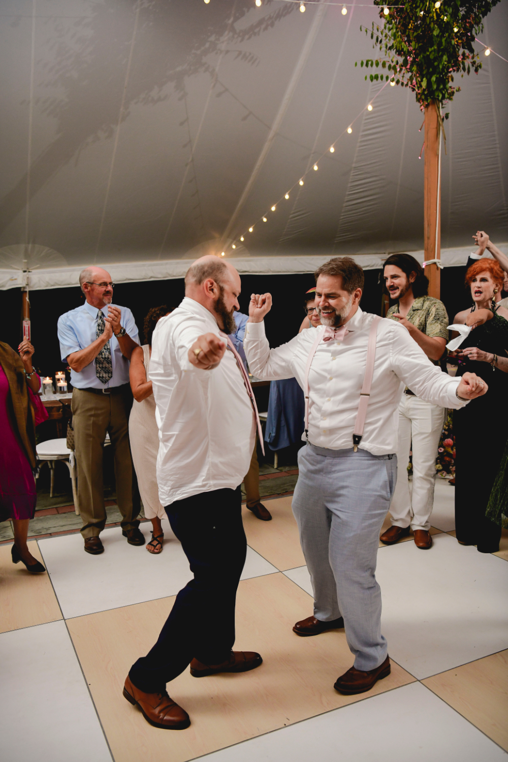 The grooms share a joyful moment on the dance floor at their Buttermilk Falls Inn wedding.