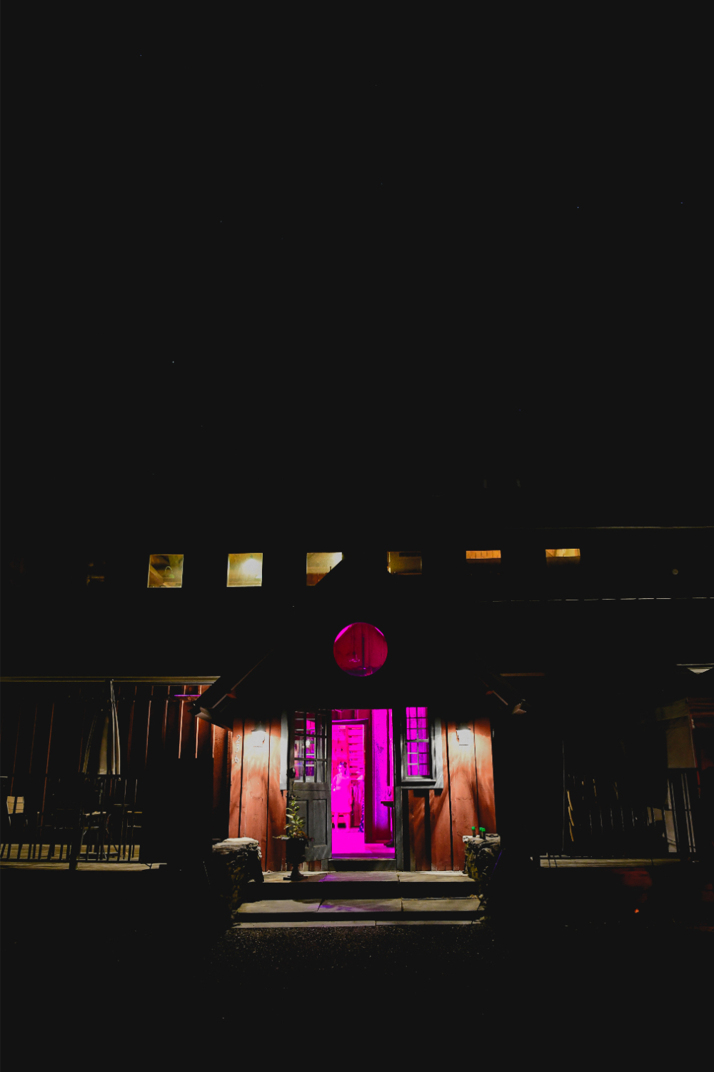 The barn glowing with retro lighting during the Buttermilk Falls Inn wedding after party.