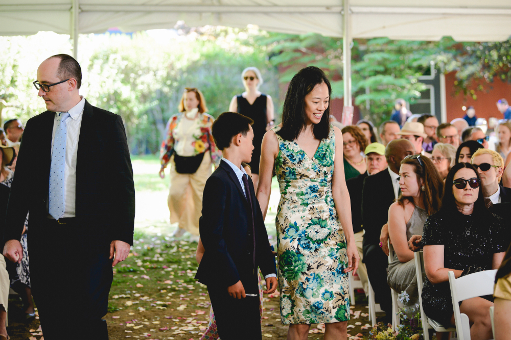 Wedding guests walk down the aisle and find their seats under the ceremony tent at a buttermilk falls inn wedding.
