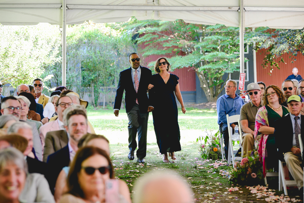 Guests walk together down the aisle toward their seats during a buttermilk falls inn wedding ceremony.