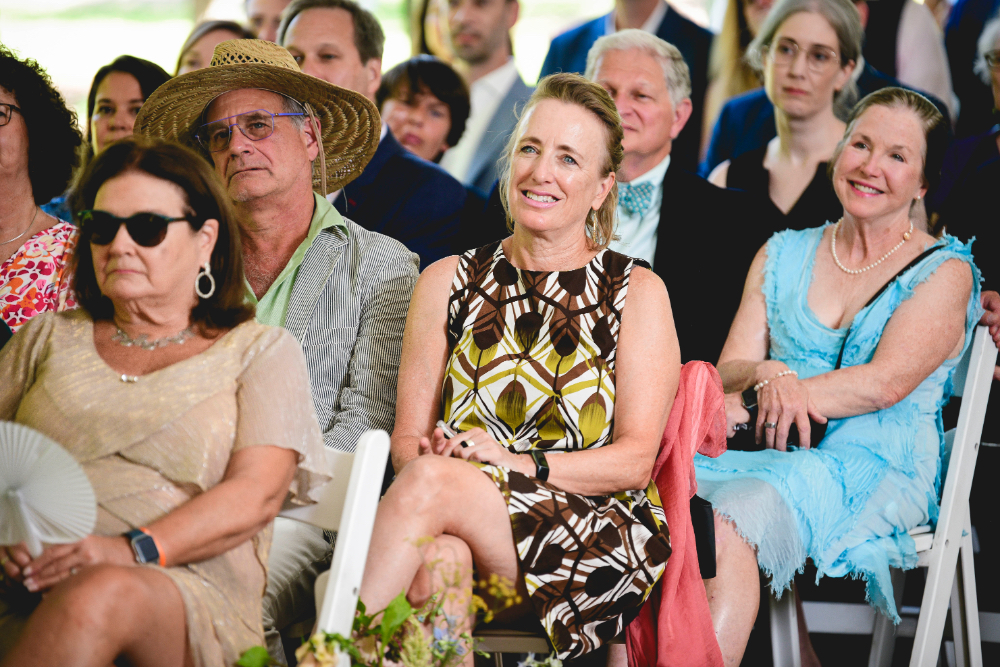 guest at wedding smiling at the ceremony outdoors tented