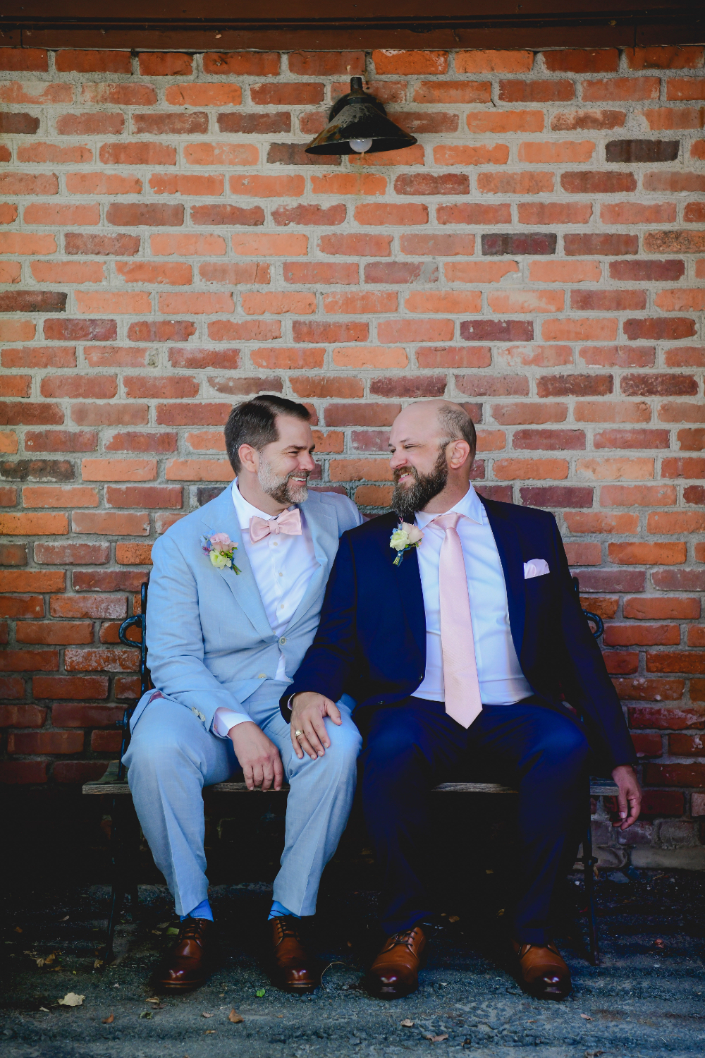 grooms sitting outside their New York wedding venue at buttermilk falls inn